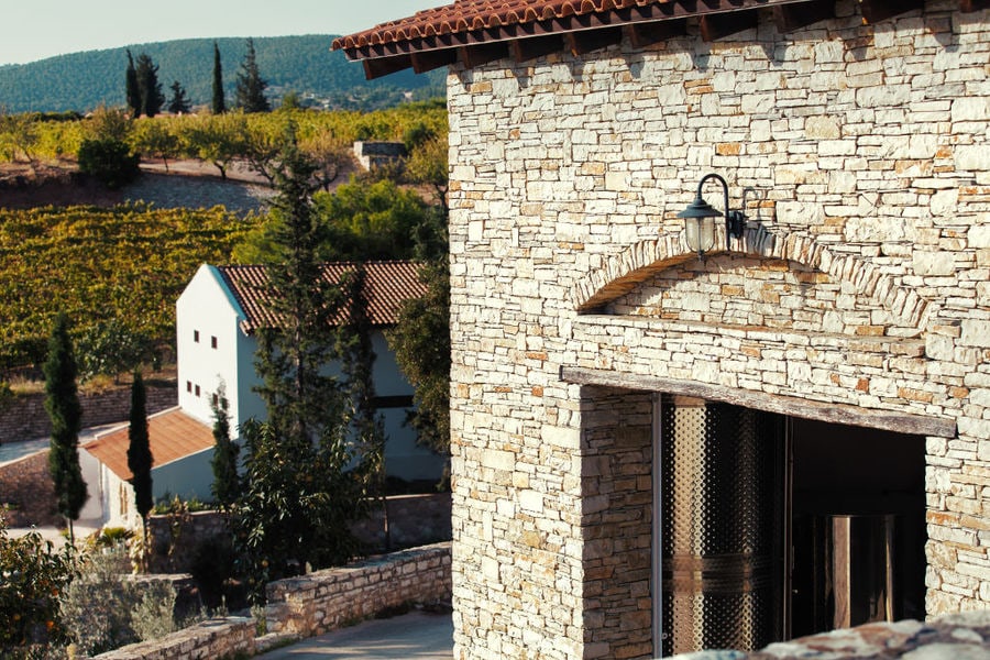 stone wall front the Chateau Kaniaris winery building and the vineyards